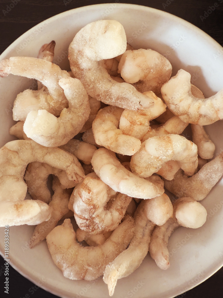 Closeup overhead shot of frozen raw king prawns, defrosting in a bowl. Closeup overhead shot of frozen raw king prawns, defrosting in a bowl.
