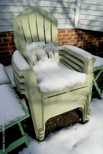 Green Adirondack chairs topped by snow photo