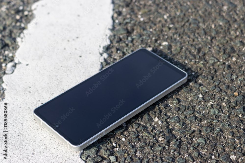 駐車場の白線近くに落ちたスマートフォン