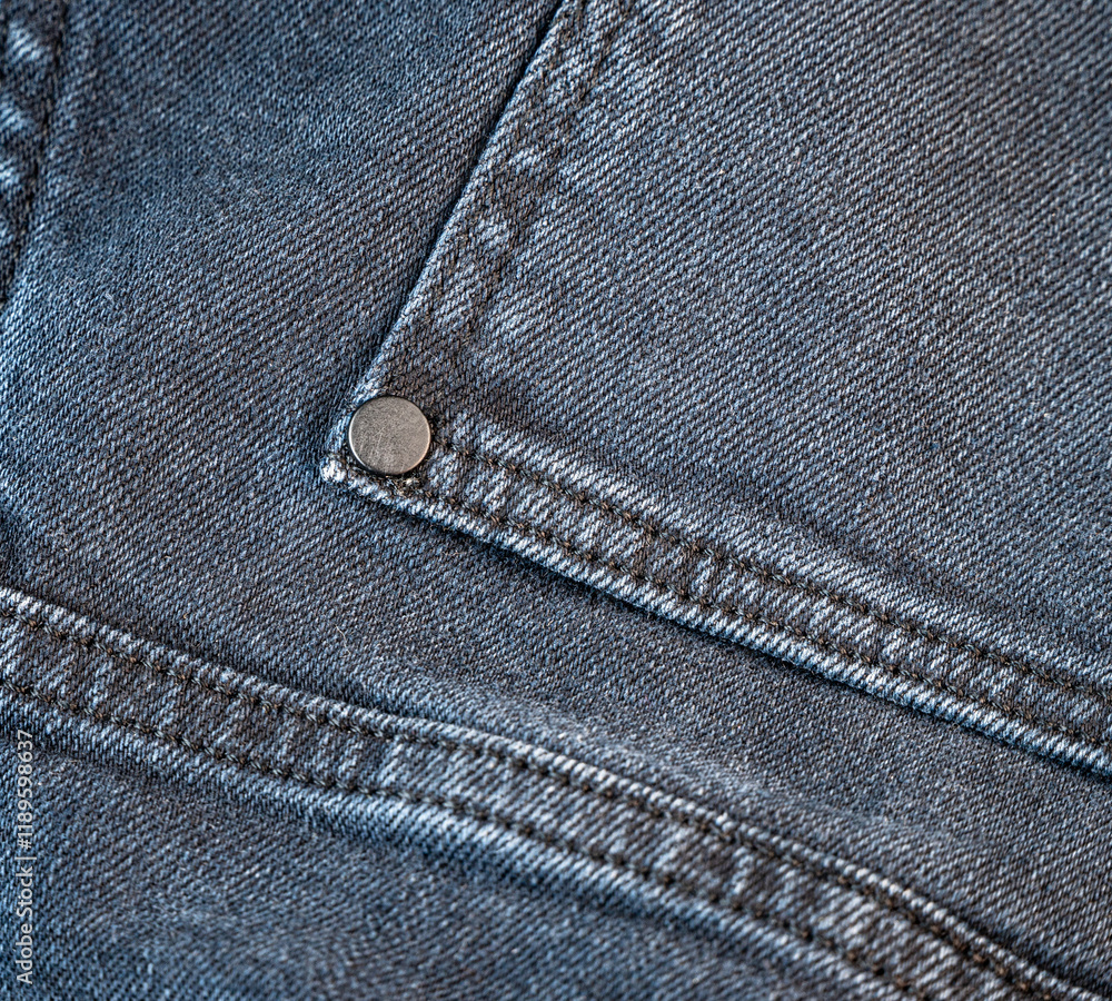 Close-up view of denim fabric with silver rivet detail Close-up view of denim fabric with silver rivet detail