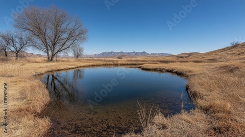 Tranquil clear pond reflecting blue sky and green hills in summer