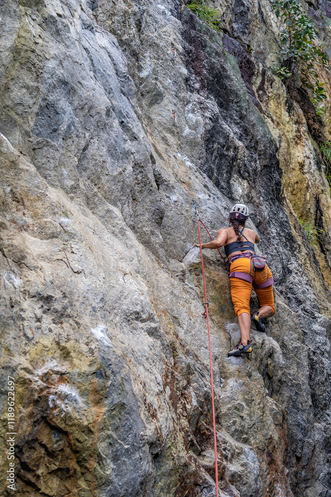 climber with sports pants demonstrating confidence and purpose in her goals to achieve an objective risking everything but at the same time safely climber with sports pants demonstrating confidence and purpose in her goals to achieve an objective risking everything but at the same time safely
