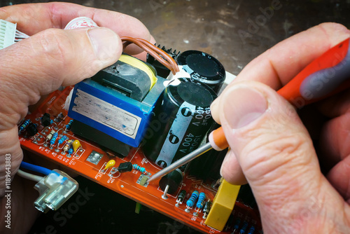 Wallpaper Mural In the photo, the hands of an old master perform repair and maintenance of electronic components of a computer. Close-up. Torontodigital.ca