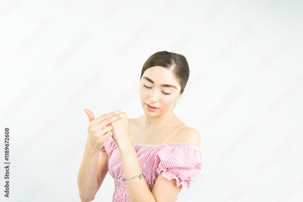 A woman applying hand lotion onto her hands A woman applying hand lotion onto her hands