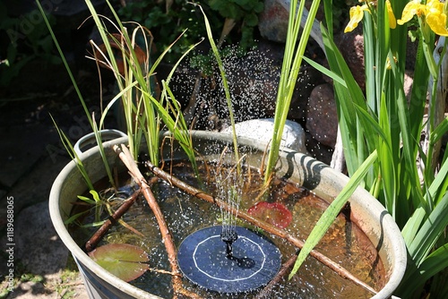 decorative metal tub in the garden full of water and a small fountain