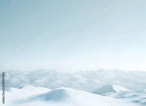 Serene Winter Mountainscape: A Panoramic View of Snow-Covered Peaks Under a Pale Sky