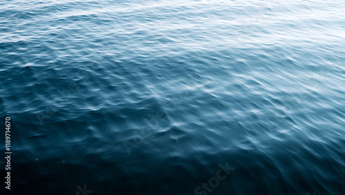 A lake's surface is dotted with ripples as wind stirs the calm water, natural elements, rippled lake surface photo