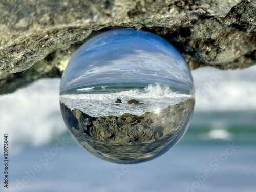 Cristal ball reflecting a seascape Bay of Biscay at Biarritz, Milady beach. Waves splashing over rocks photo