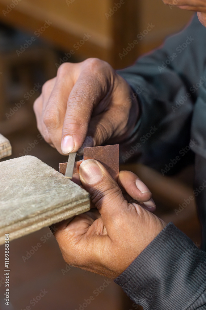 Fototapeta premium Artisan - Craftmand sawing a piece of metal with a artesanal saw