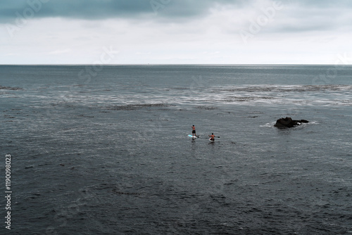 two people paddle boarding in the open sea