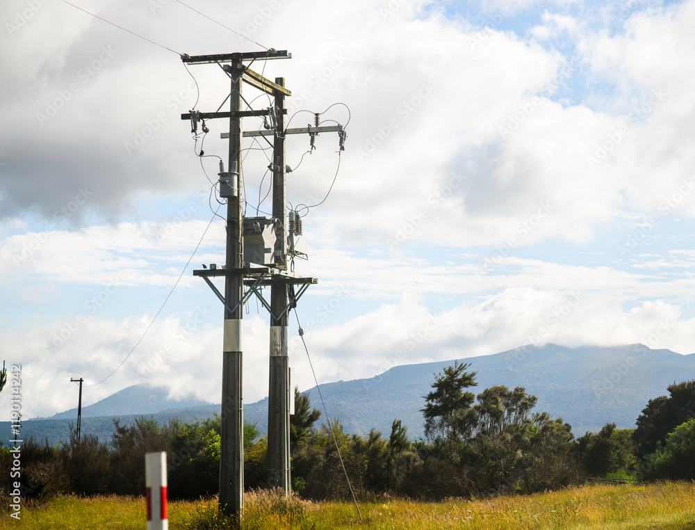 Transformer of an electrical post along the motorway. Mountains in the background. North Island. New Zealand.
