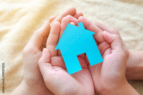 Hands Holding Blue House Symbol Symbolizing Home Ownership and Protection Concept photo