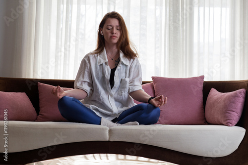 Young woman meditating on couch at home Free Download Young woman meditating on couch at home - GFXLoad