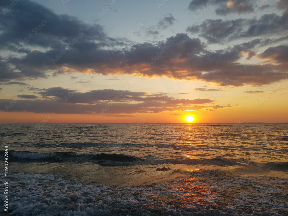 Obraz premium A breathtaking sunset over the ocean, captured at the water's edge