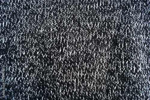 Knitting basics: stocking stitch close-up. Front side of the product, created in stockinette stitch technique from beautiful two-color yarn. Fragment of a sweater: black and white wool fabric. photo