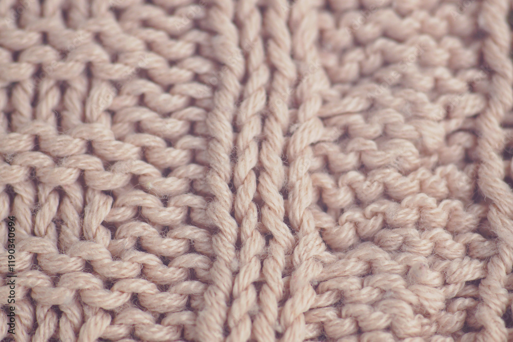 Texture of a sweater knitted using a complex technique: close-up patterns on fabric made of fluffy light pink yarn. Knitting techniques for advanced users: a sample of a finished product. Texture of a sweater knitted using a complex technique: close-up patterns on fabric made of fluffy light pink yarn. Knitting techniques for advanced users: a sample of a finished product.