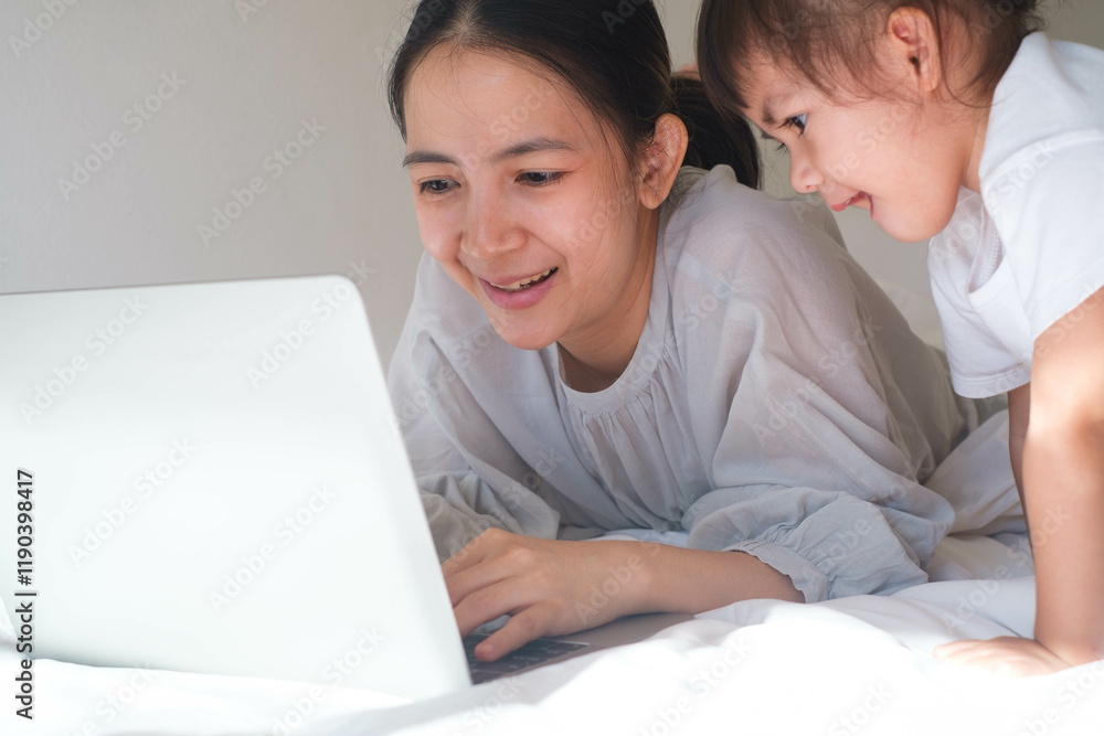 A joyful moment captured between a mother and daughter as they explore a laptop together, showcasing connection and learning. A joyful moment captured between a mother and daughter as they explore a laptop together, showcasing connection and learning.