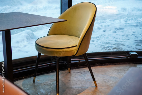 Cozy chair by the window overlooking snowy Rotermanni in Tallinn, Estonia for a warm dining experience photo