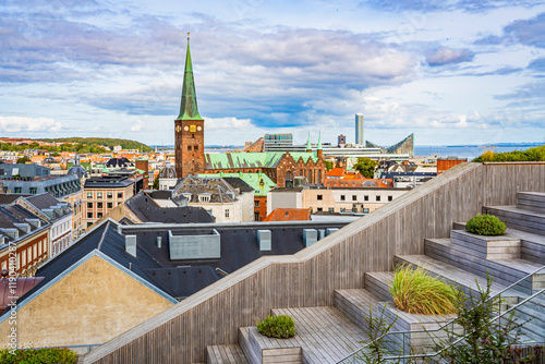 Weitblick von einer Dachterrasse auf die Dächer, den Dom und Gebäude von Aarhus, blauer Himmel, leicht bewölkt, horizontal photo