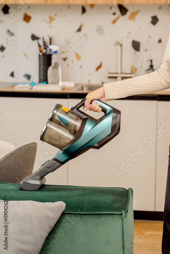 Cuadro en lienzo The process of cleaning a sofa with a vacuum cleaner with a special nozzle
