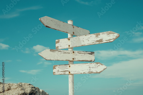 Image of five blank white road signs pointing in different directions against a bright blue sky with scattered clouds.  
