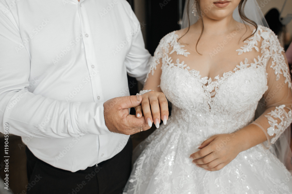 Father holding daughter's hand on wedding day Father holding daughter's hand on wedding day