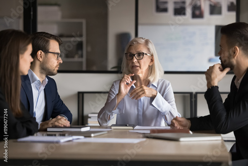 Fotografija Businesswoman, company boss explains contract details to shareholders, sit at conference table, make speech, provide information, share opinion and strategy, engaged in teamwork activity
