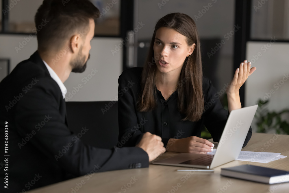 Two male female colleagues engaged in conversation, lead serious discussion at conference table at meeting in office, consider issue solution, sharing opinion, strategy, planning cooperation. Teamwork Two male female colleagues engaged in conversation, lead serious discussion at conference table at meeting in office, consider issue solution, sharing opinion, strategy, planning cooperation. Teamwork