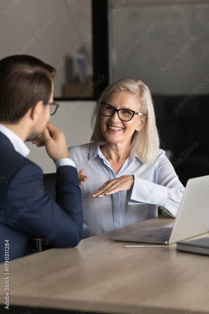 Smiling middle-aged professional female manager, bank advisor talking to client at business meeting, having discussion, share ideas, make commercial offer, working on joint project in office. Teamwork Smiling middle-aged professional female manager, bank advisor talking to client at business meeting, having discussion, share ideas, make commercial offer, working on joint project in office. Teamwork