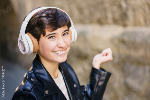 A Young Person Happily Enjoying Their Favorite Music While Wearing Headphones in an Urban Setting photo