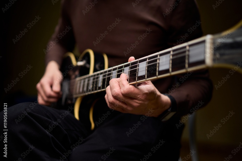 Obraz premium Close Up of Hands Playing a Guitar in a Warm and Cozy Setting Filled with Music and Art
