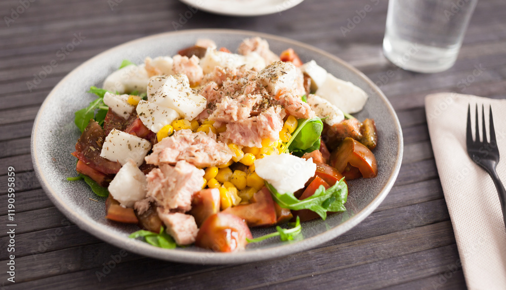 Plate of salad with tuna, corn, tomatoes and arugula Plate of salad with tuna, corn, tomatoes and arugula