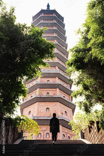 (Selective focus) Stunning view of a tourist walking under the Bai Dinh Pagoda in Ninh Binh, Vietnam. The Bai Dinh Pagoda is one of the largest pagoda complexes in Southeast Asia.