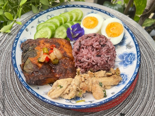 Steamed curry fish, baked garlic chicken, boiled egg and berry rice. photo