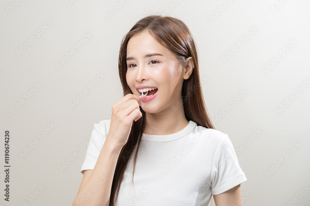 Flossing teeth, dental care hygiene concept, asian young woman flossing teeth with dental floss, smile happy with perfect white teeth, using tooth floss cleaning, healthy teeth isolated on background. Flossing teeth, dental care hygiene concept, asian young woman flossing teeth with dental floss, smile happy with perfect white teeth, using tooth floss cleaning, healthy teeth isolated on background.
