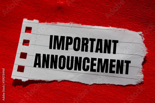 Fotografija Important announcement message written on ripped torn paper piece with red background