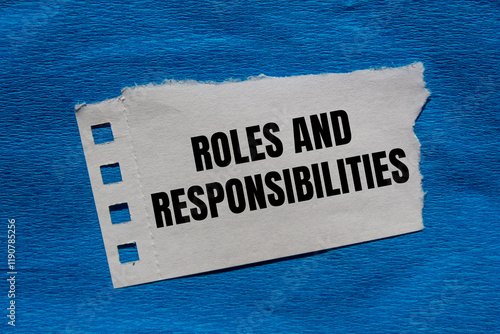 Foto Roles and responsibilities message written on ripped torn paper piece with blue background