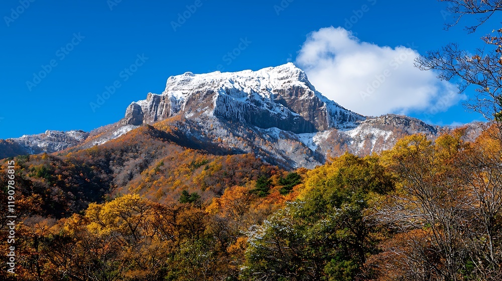 Majestic snow-capped mountain towering over vibrant autumn foliage under a clear blue sky Majestic snow-capped mountain towering over vibrant autumn foliage under a clear blue sky
