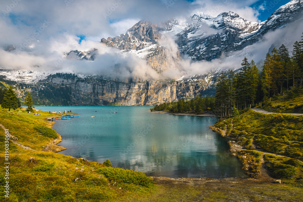 Oeschinensee lake and misty snowy mountains in background, Kandersteg, Switzerland