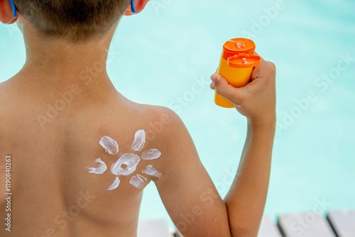smiling boy wearing glasses and sunscreen with a sun painted on his shoulder. sun protection