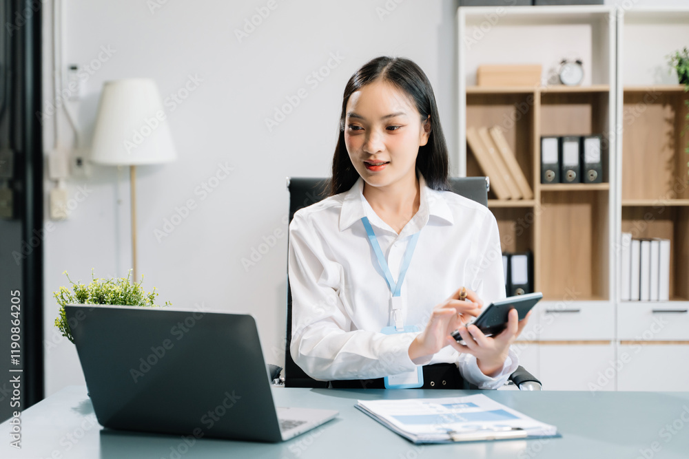 Young Asian businesswoman working with working notepad, tablet and laptop documents talking Young Asian businesswoman working with working notepad, tablet and laptop documents talking