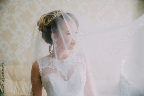 A woman in a white wedding dress is standing in front of a curtain, with her face partially hidden. Concept of mystery and anticipation, as the bride-to-be is about to enter the room for her wedding photo