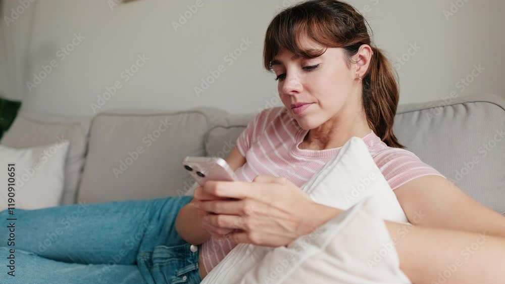 Woman using phone, relaxing on sofa. Cozy home, domestic life, casual leisure. Woman using phone, relaxing on sofa. Cozy home, domestic life, casual leisure.