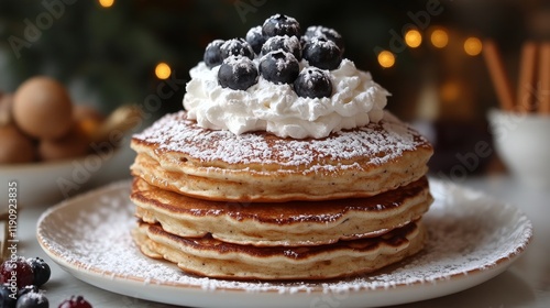 Fluffy pancakes stacked high with whipped cream and fruit toppings served on ...