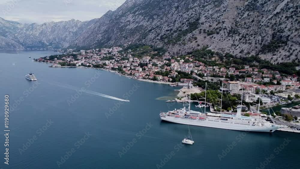 Drone scene of The Bay of Kotor with mountain view and a cruise ship behind the town Drone scene of The Bay of Kotor with mountain view and a cruise ship behind the town