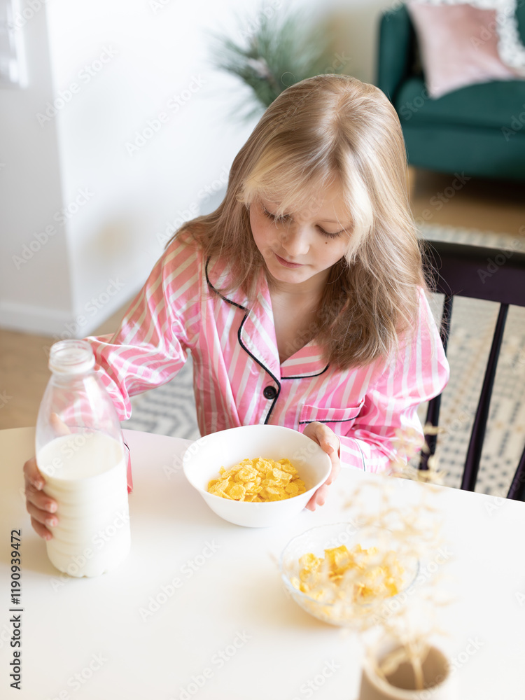 girl pouring milk into cornflakes, breakfast girl pouring milk into cornflakes, breakfast