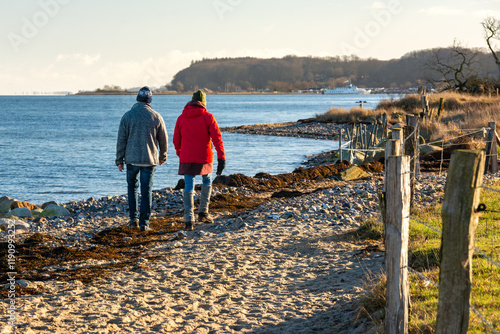 Two people walking through the dunes in coastal landscape at the Baltic Sea