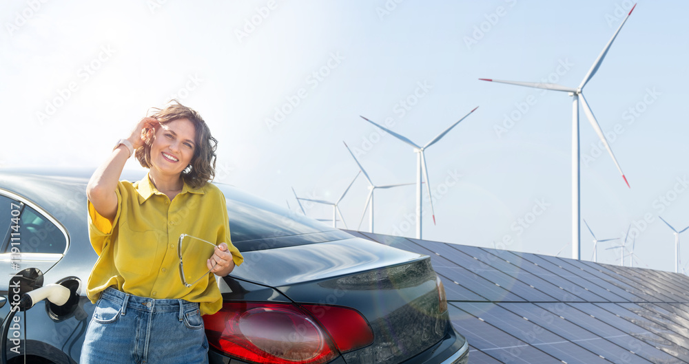 Φωτογραφία Woman with curve hairs wearing yellow shirt stands next to charging electric car