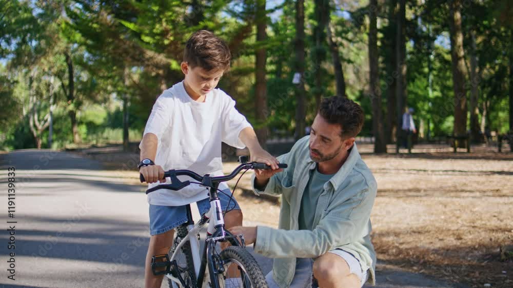 Daddy explaining child cycling in autumn park closeup. Kid learning ride bike Daddy explaining child cycling in autumn park closeup. Kid learning ride bike