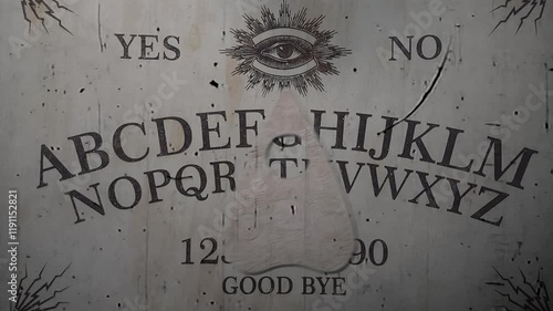 Ouija board's pointer moves on its own and writes the word spiritism